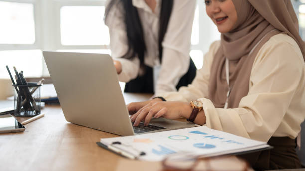 istock A professional Asian-Muslim businesswoman using her laptop while discussing work with her colleague. 1751245245