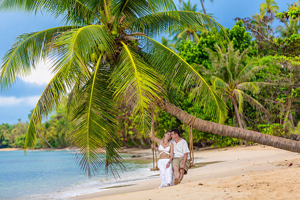 istock Happy couple sitting on the sunny beach 175125077