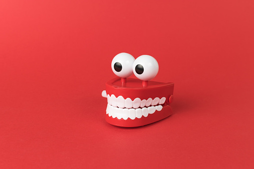 Wind-up toy mouth and eyes on a red background. The concept of a holiday and parties.
