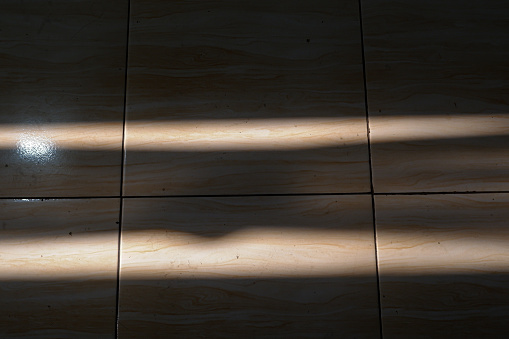 Exposure to light on a tiled floor, light on the floor from a window.