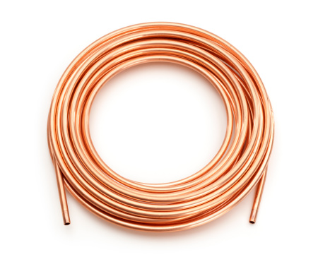 Coil of copper tubing pipe, isolated on white.