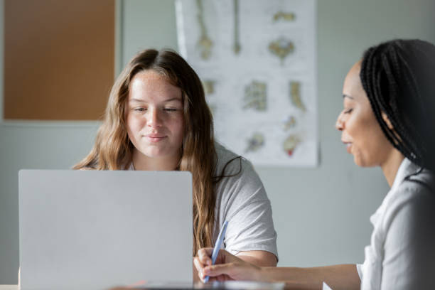 istock Two college mates indoors, partnering on research while making use of a laptop 1751317560