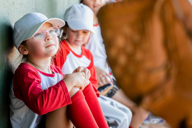 istock Little league baseball team sit together in dugout during game 1751346359
