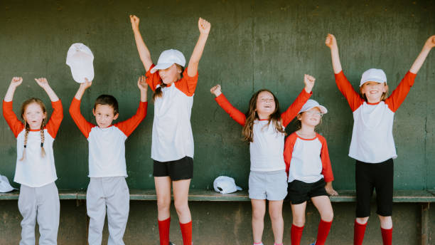 Coed baseball team enthusiastically cheering in the dugout