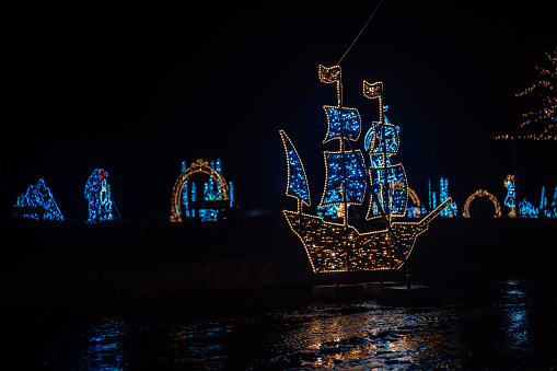 Christmas installations from garlands.shining ship made of garlands in the dark.Glowing decorative holiday objects.