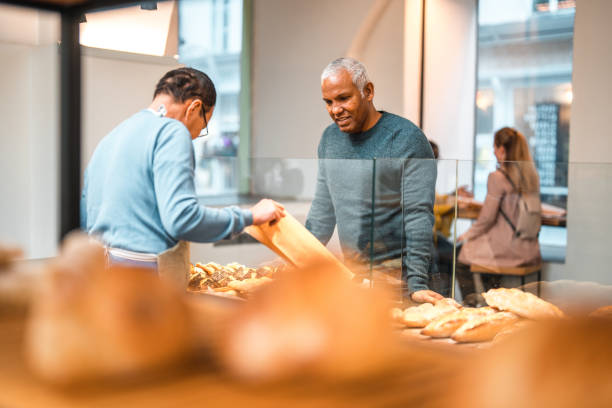 istock Mature Hispanic Male Selecting Fresh Bread At An Artisan Bakery 1751361817