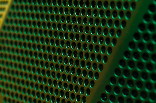 Dark green metallic background with holes. metal mesh