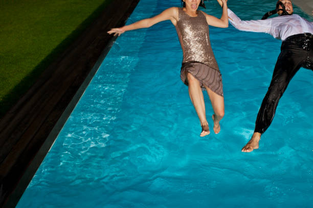 Fully dressed couple jumping into swimming pool  person falling backwards stock pictures, royalty-free photos & images