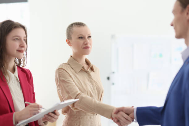 istock Happy manager watches colleagues shaking hands in office 1751389242