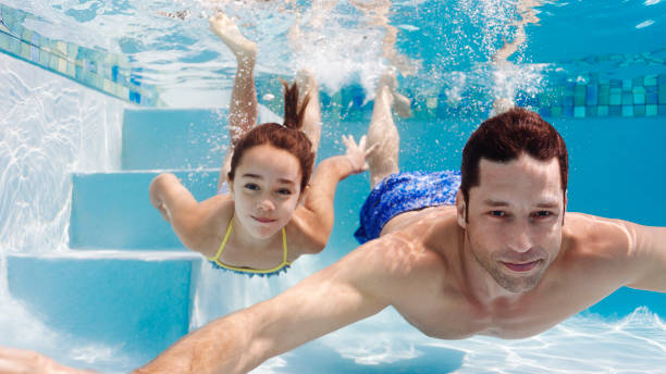istock Father and daughter swimming in pool 175139086