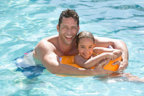 istock Father and daughter relaxing in swimming pool 175139195