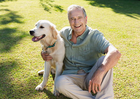 Senior Caucasian man embracing his Maltese dog puppy
