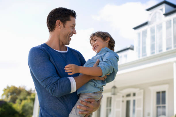 istock Father and son smiling outside house 175139216