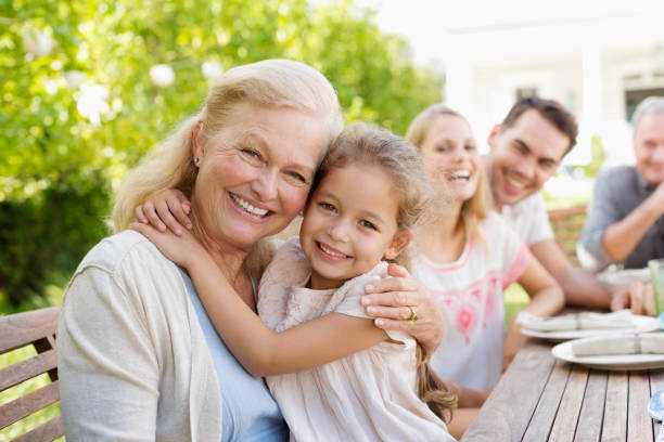 mujer de edad avanzada y granddaughter sonriendo al aire libre - child picnic smiling outdoors fotografías e imágenes de stock