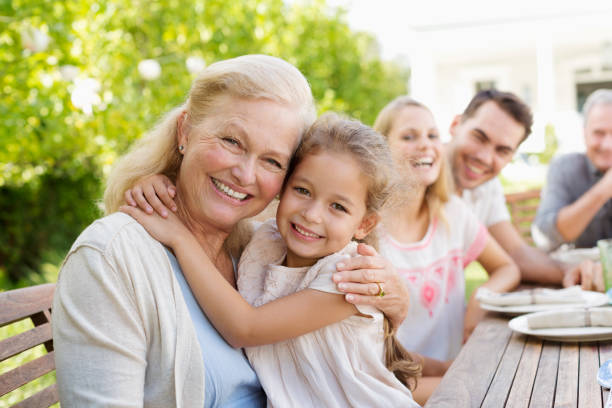 Older woman and granddaughter smiling outdoors  cheek to cheek stock pictures, royalty-free photos & images