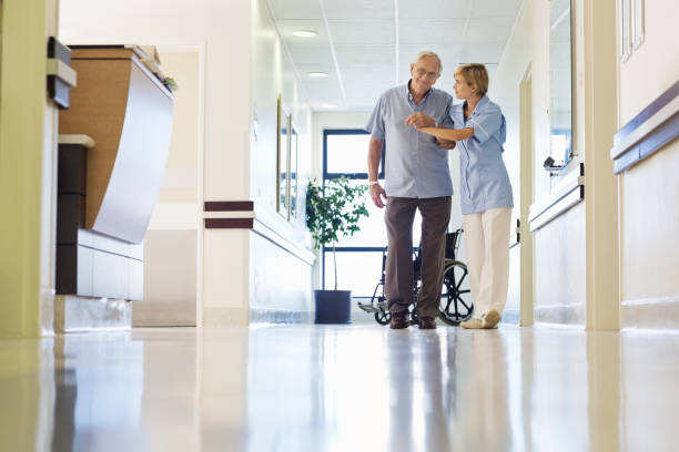 istock Nurse helping patient walk in hospital hallway 175139327