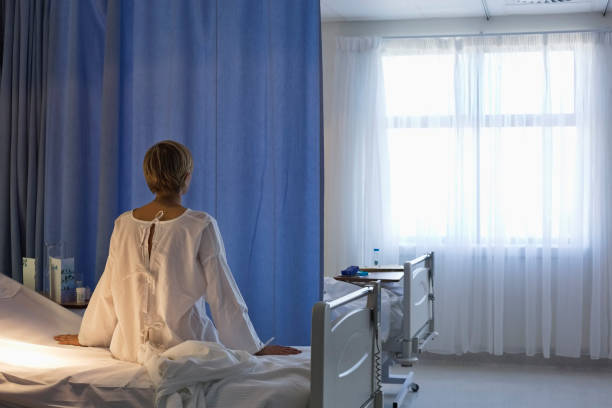 la paciente usa ropa de cama de hospital - examination gown fotografías e imágenes de stock