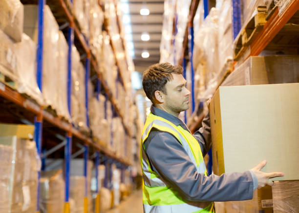 Worker stacking boxes in warehouse stock photo