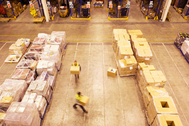 istock Blurred view of workers carrying boxes in warehouse 175139528