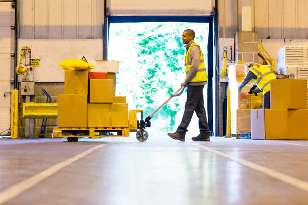 Worker carting boxes in warehouse  loading bay stock pictures, royalty-free photos & images