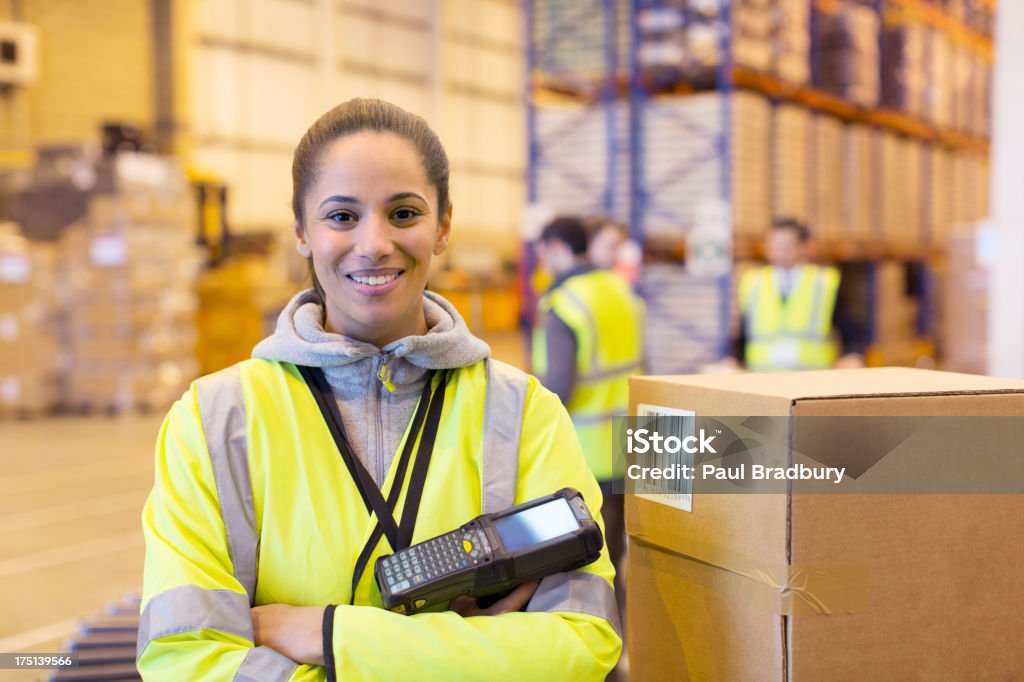 Worker holding scanner in warehouse  Warehouse Stock Photo
