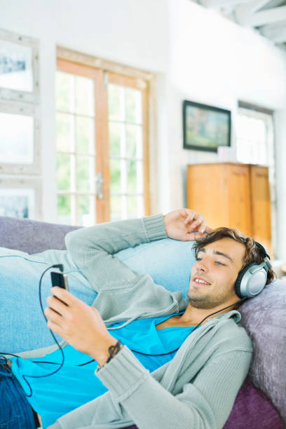 istock Man listening to headphones on sofa 175139753
