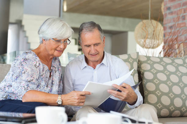 istock Older couple reading papers together on sofa 175139822