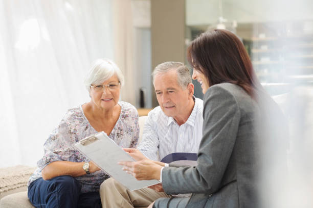 financial advisor reden paar auf sofa - explaining men pointing talking stock-fotos und bilder