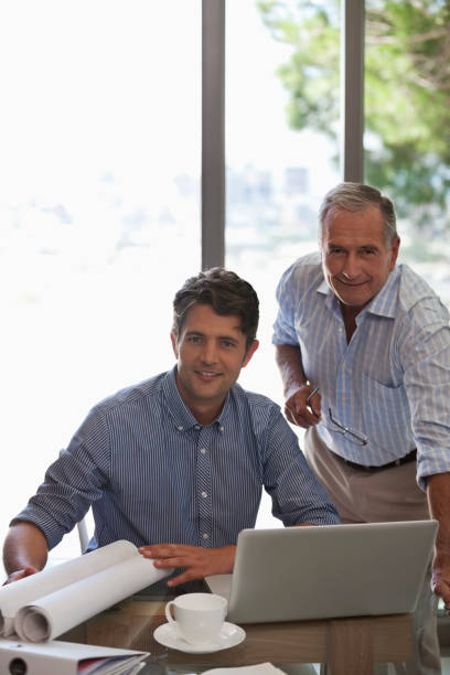 istock Older man and younger man working together at desk 175139909
