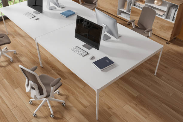 istock White computer table in wooden floor office, top view 1751408637