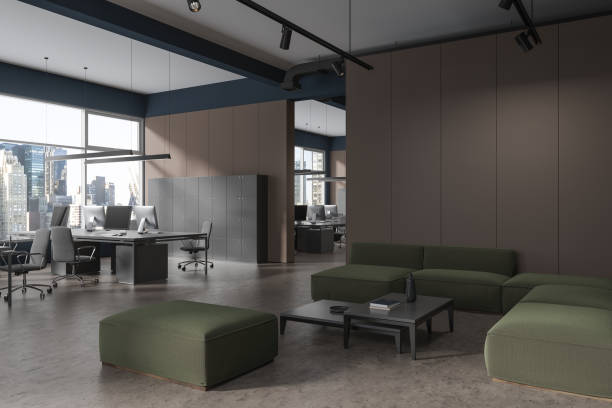 istock Dark coworking interior work desk in row and lounge zone with couch 1751409167