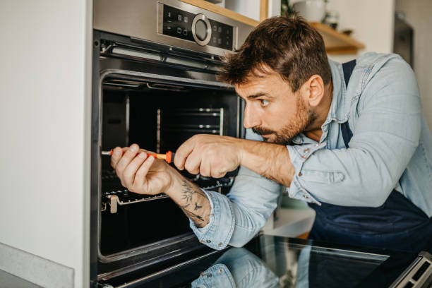istock Experienced male handyman seamlessly integrating a new oven into a kitchen setup, ensuring seamless functionality and efficient use for homeowners 1751456494