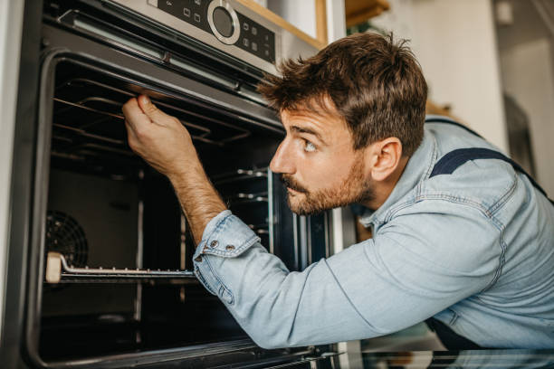 istock Diligent carpenter expertly handling an oven repair project, equipped with specialized tools and a keen eye for identifying and resolving technical issues 1751456527