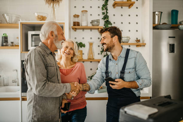 istock Seniors settle bill with carpenter on his phone after quick house fixes 1751460916