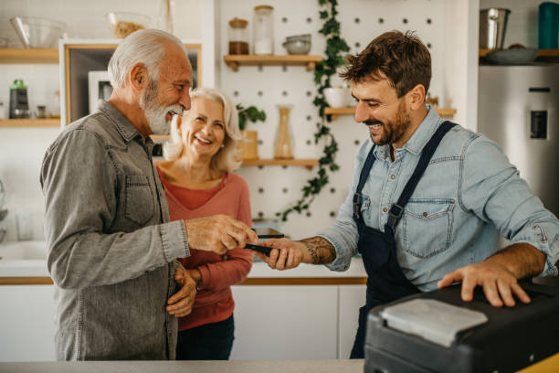 istock An experienced carpenter is seen finalizing a home repair project for an elderly couple, seamlessly handling payment through a convenient mobile app 1751460918