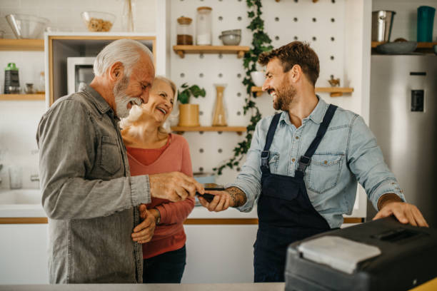 istock An experienced carpenter is seen finalizing a home repair project for an elderly couple, seamlessly handling payment through a convenient mobile app 1751460920