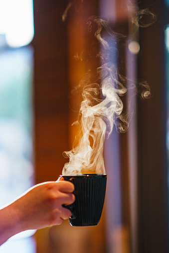 A cup of hot drink with smoke