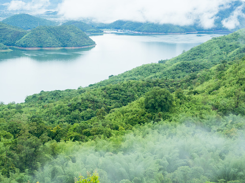 Srinakarin Dam (Khwae Yai River) with mist and cloud over lake water in the morning, Kanchanaburi Thailand