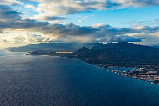 Clouds above the ocean with an island. Oahu, Hawaii.