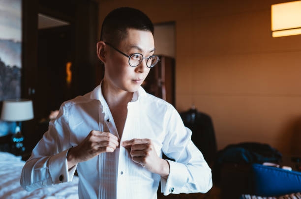 Asian Man Putting on Tuxedo for Events Asian Man Putting on Tuxedo for Events dinner jacket stock pictures, royalty-free photos & images