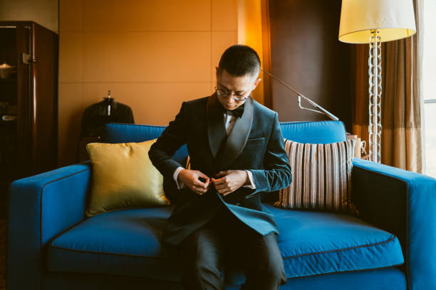 Asian Man Putting on Tuxedo for Events Asian Man Putting on Tuxedo for Events dinner jacket stock pictures, royalty-free photos & images