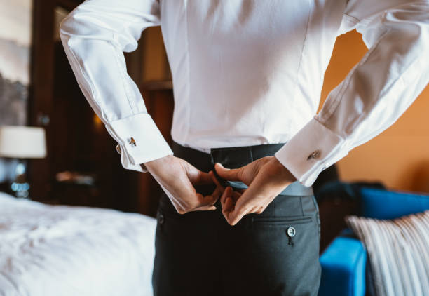 Man corrects belt, fees groom, man's hands, dressing, man buttons pants, jeans