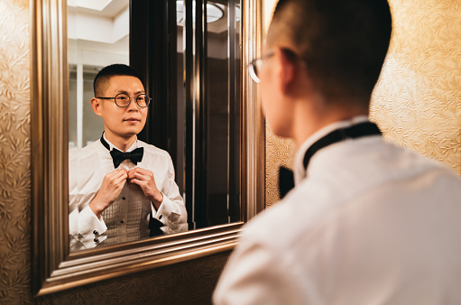 Asian Man Putting on Tuxedo for Events