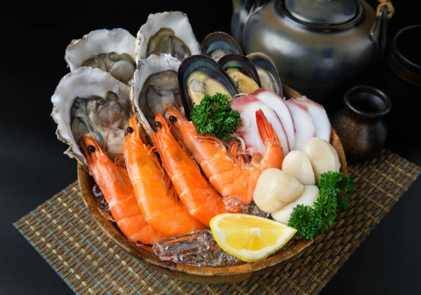istock Seafood on a large plate set with dark background. 1751539692