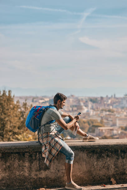 istock Young male tourist using phone while exploring big city 1751552155
