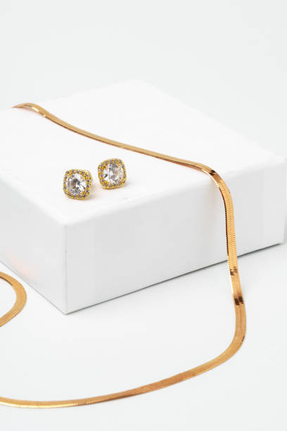 Golden diamond neacklace and earrings on white background