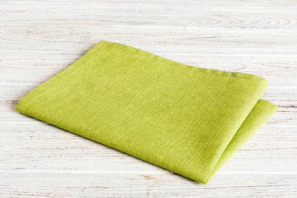istock top view with green kitchen napkin isolated on table background. Folded cloth for mockup with copy space, Flat lay. Minimal style 1751573394