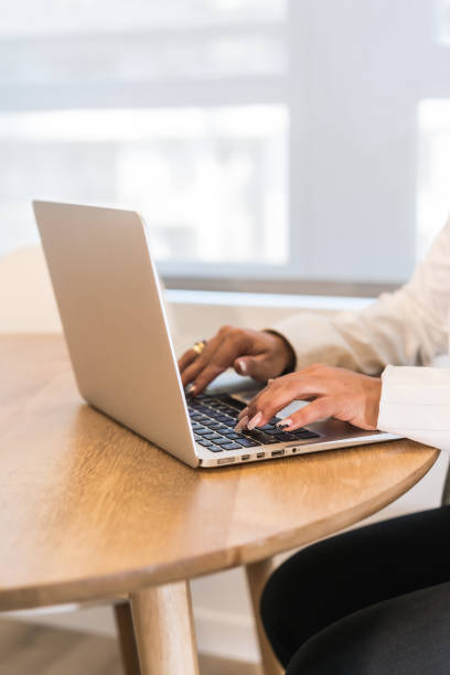 istock Woman's hands working on laptop at wooden table 1751603506