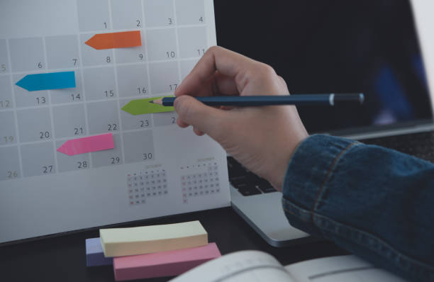 istock 2024 Event planner timetable agenda plan on schedule event. Business woman checking planner, taking note on calendar desk with laptop computer on office table. Calendar event plan, work planning 1751611186