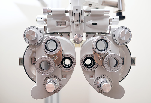 Phoropter, hospital and eye exam for health, check and lens for vision, wellness and helping with machine. Ophthalmology, glasses and test with healthcare, metal frame and care for eyesight in clinic